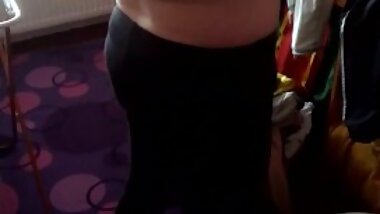 She pulls on her leggings, in her bra