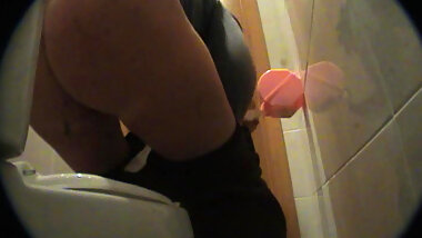 Alluring babe takes off her nice black stockings in a toilet